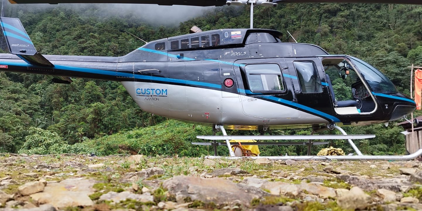 Bell 206 de Custom posado en un sitio rocoso en medio de la selva