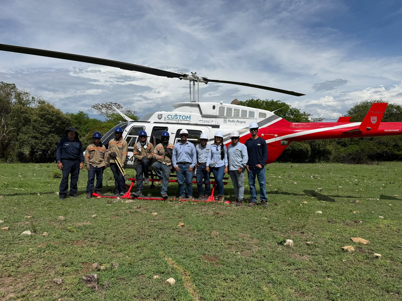 Tripulación y cuadrilla de Custom Aviation frente al Bell 206