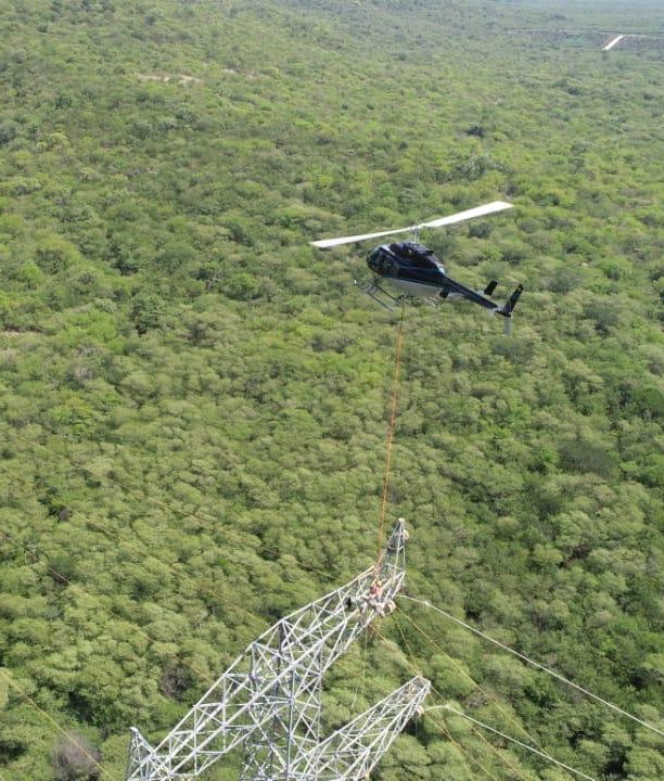 Helicóptero de Custom con línea larga sobre una torre en montaje