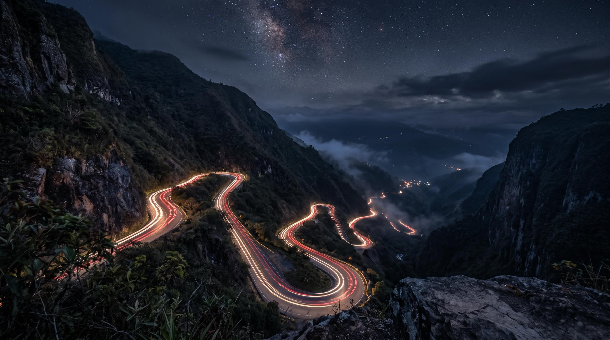 Carretera de montaña de noche con las estelas de los vehículos